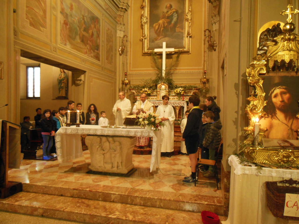 Don Mauro raggiunge la sede. Attorno a lui i dodici ragazzi prescelti per il rito della lavanda dei piedi.