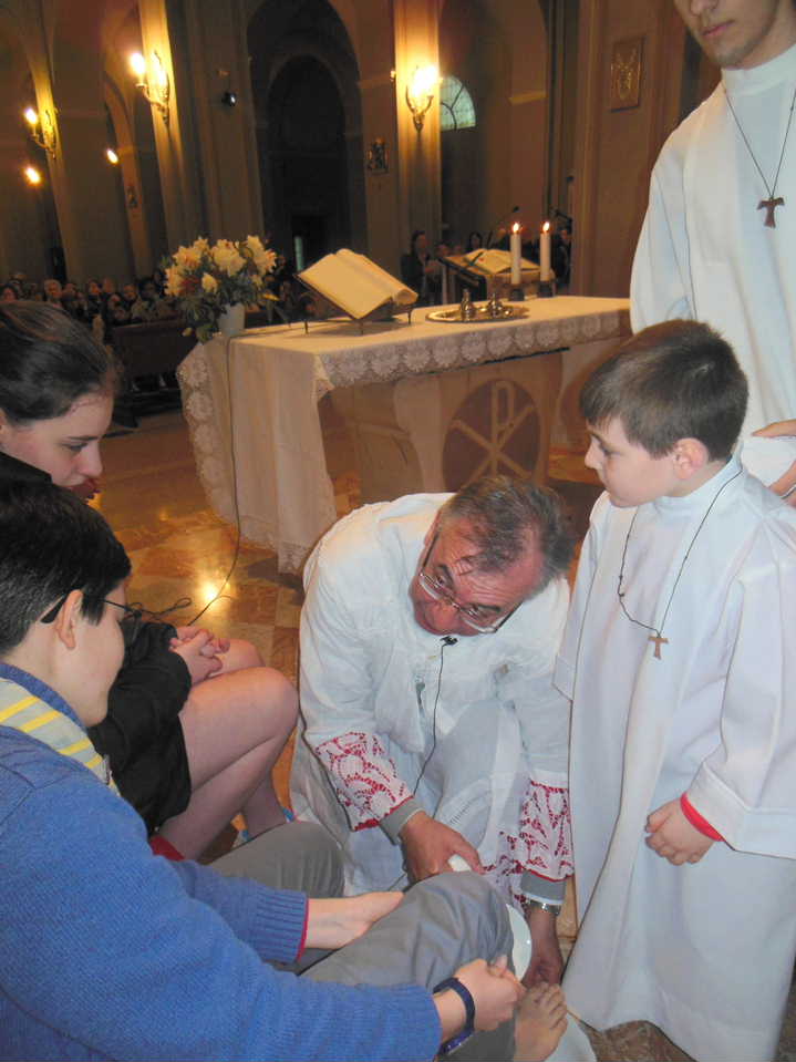 Dopo essersi tolto i paramenti e aver indossato il grembiule, don Mauro procede a lavare i piedi dei dodici prescelti.