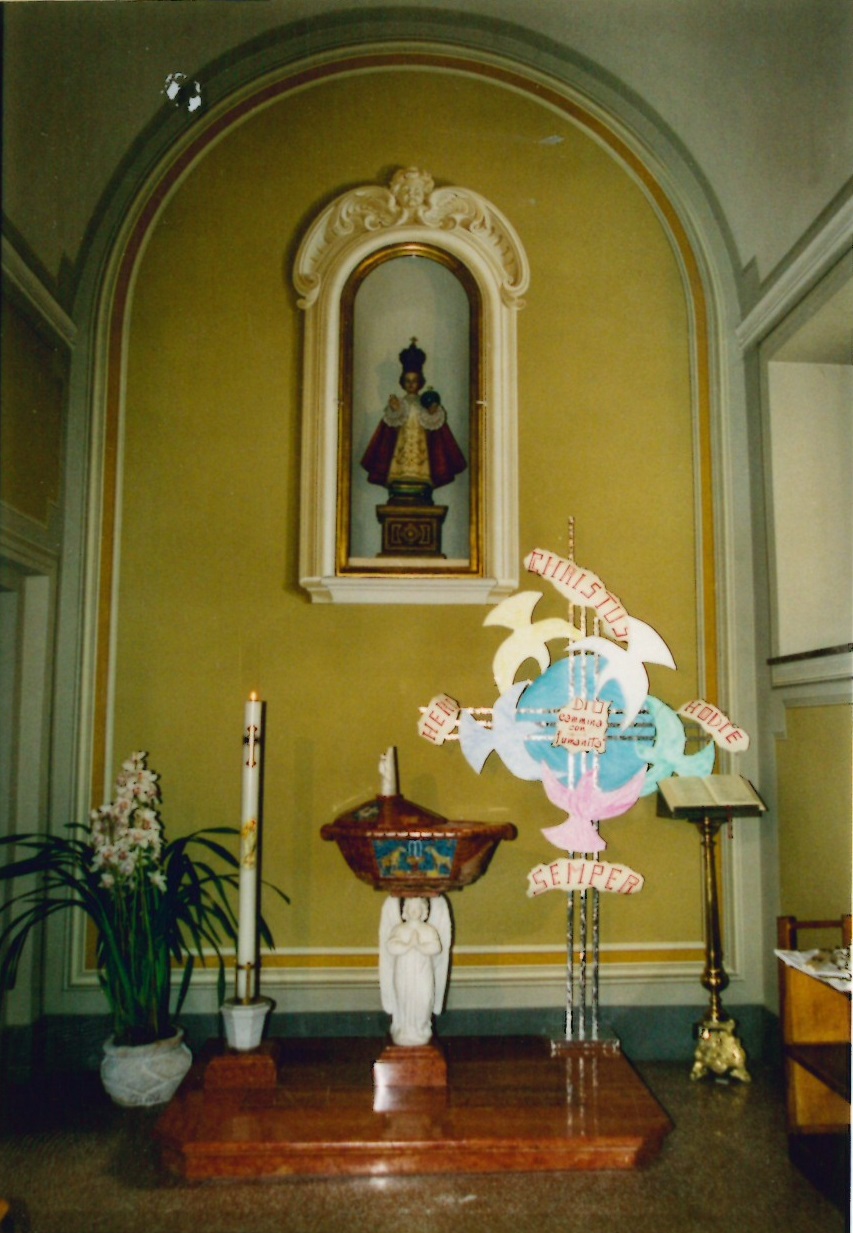 1. Il Battistero. Sulla parte la statua del Santo Bambino di Praga.
